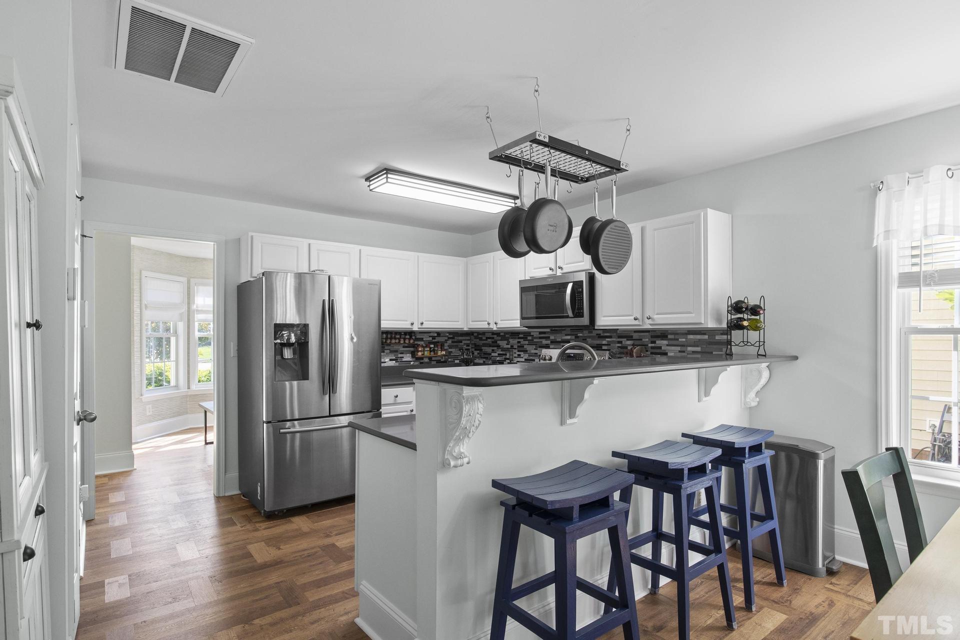 1727 Crag Burn Lane Raleigh, NC 27604 - Photo 7 of 43 a kitchen with stainless steel appliances kitchen island a refrigerator and wooden floor