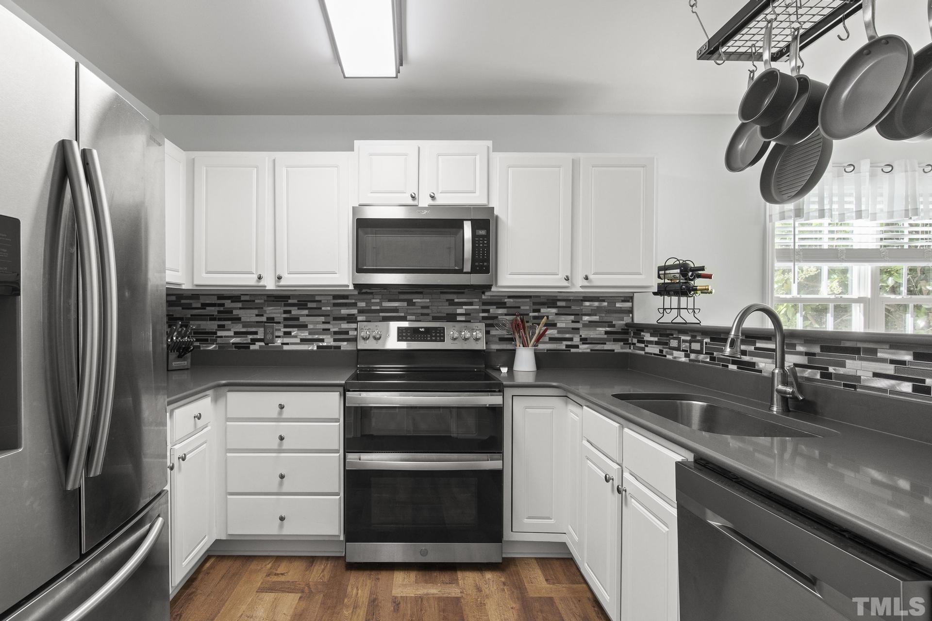 1727 Crag Burn Lane Raleigh, NC 27604 - Photo 8 of 43 a kitchen with kitchen island granite countertop a sink and stainless steel appliances