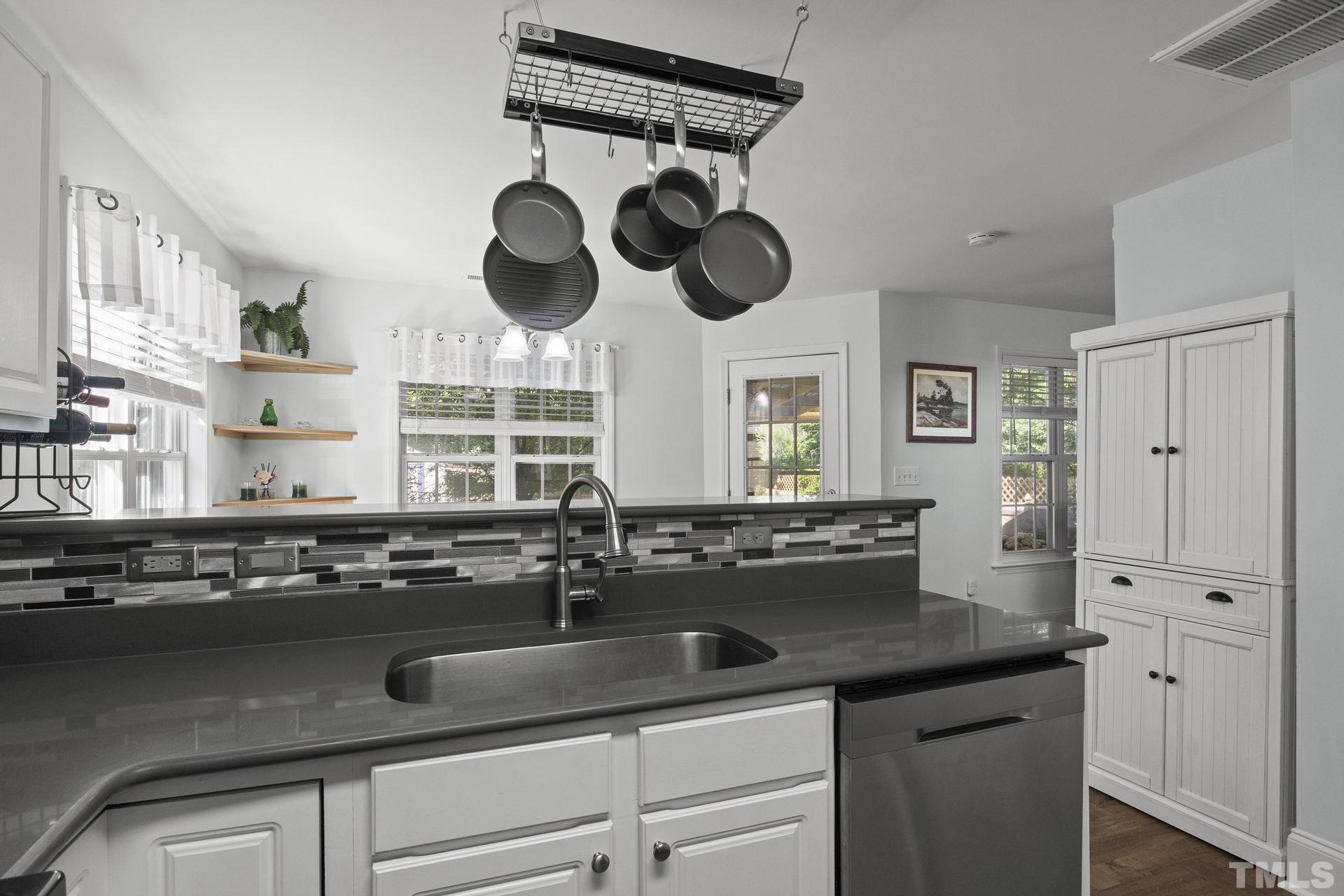 1727 Crag Burn Lane Raleigh, NC 27604 - Photo 10 of 43 a kitchen with a sink dishwasher and white cabinets
