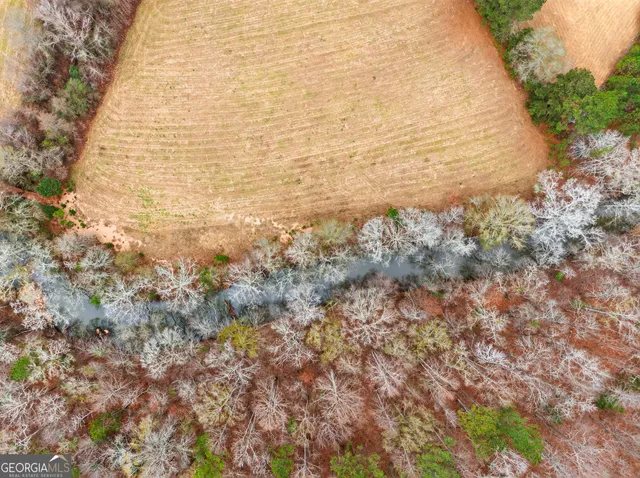 a view of a house with a big yard and large trees