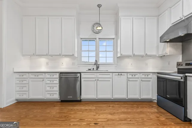 a kitchen with kitchen island granite countertop a sink stainless steel appliances and cabinets