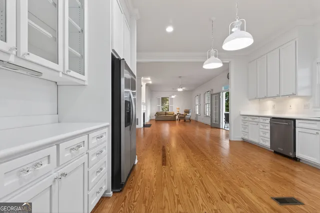 a view of a living room with wooden floor and a fireplace