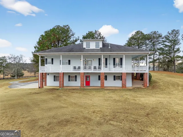 a view of a house next to a big yard with large trees