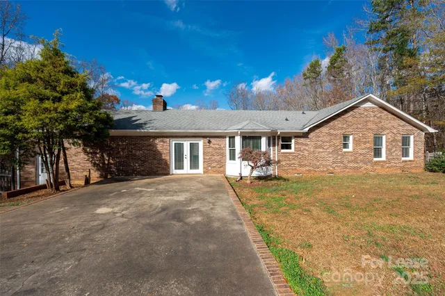 a view of a house with a yard and potted plants