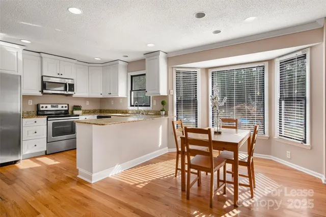 a kitchen with microwave a stove a table and chairs