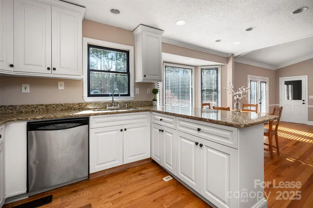 a kitchen with granite countertop white cabinets and white appliances