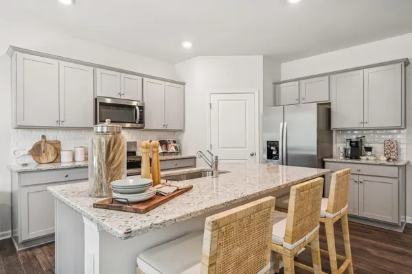 a kitchen with kitchen island granite countertop a sink stove and refrigerator