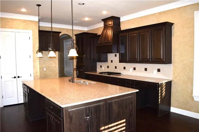 a kitchen with stainless steel appliances kitchen island granite countertop a sink a microwave and cabinets