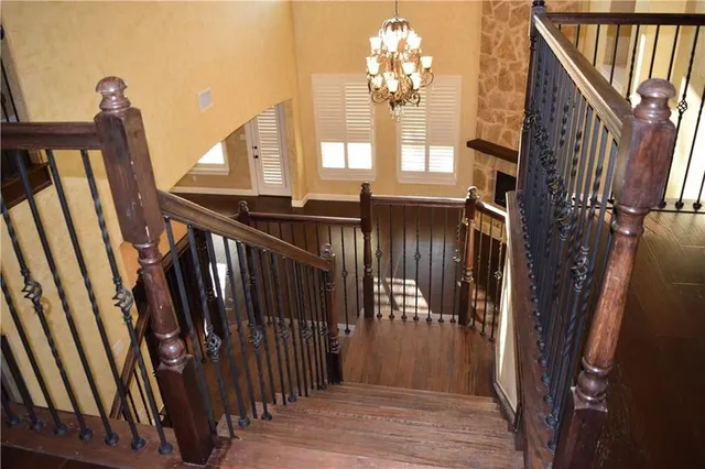 a view of a hallway with wooden floor and staircase