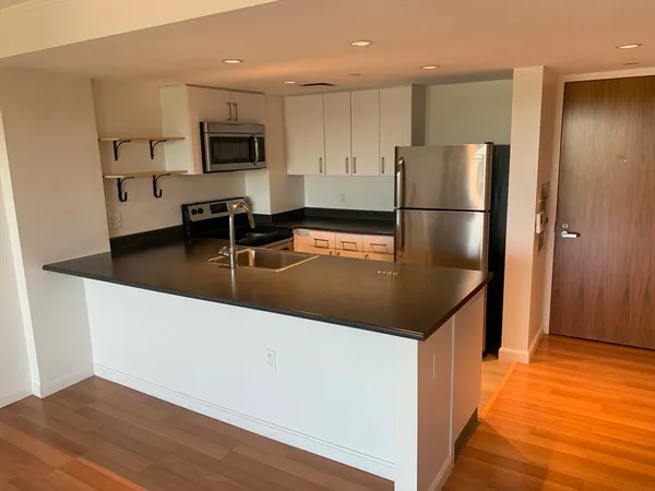 a kitchen with stainless steel appliances granite countertop a refrigerator a stove and a sink