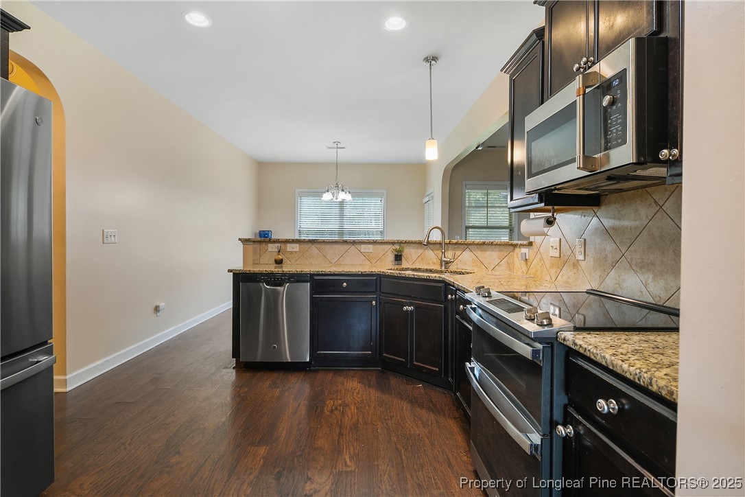 945 Pecan Grove Loop Hope Mills, NC 28348 - Photo 11 of 42 a kitchen with stainless steel appliances granite countertop a stove a sink and a microwave