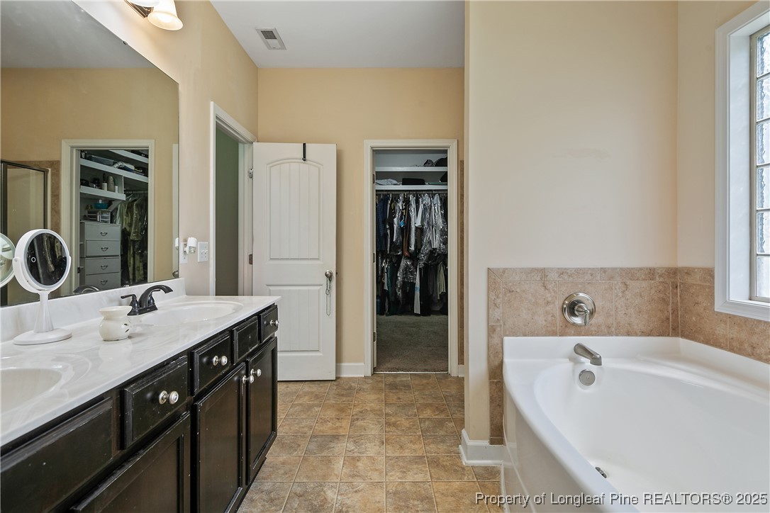 945 Pecan Grove Loop Hope Mills, NC 28348 - Photo 24 of 42 a spacious bathroom with a tub sink and mirror