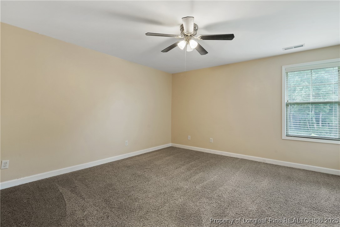 945 Pecan Grove Loop Hope Mills, NC 28348 - Photo 32 of 42 an empty room with a window and a fan
