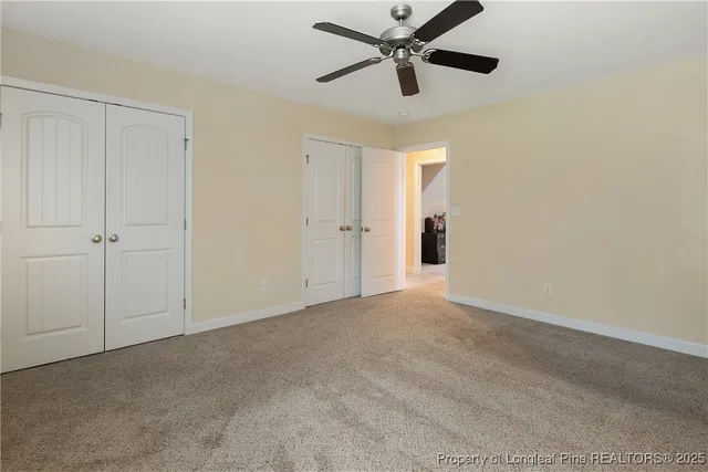 an empty room with a ceiling fan and a window
