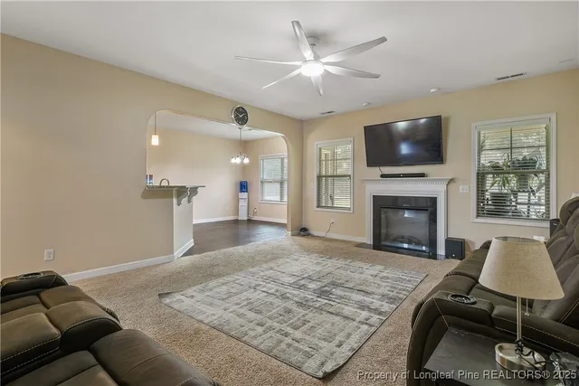 a living room with furniture a flat screen tv and a fireplace