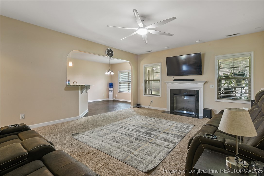 945 Pecan Grove Loop Hope Mills, NC 28348 - Photo 6 of 42 a living room with furniture a flat screen tv and a fireplace