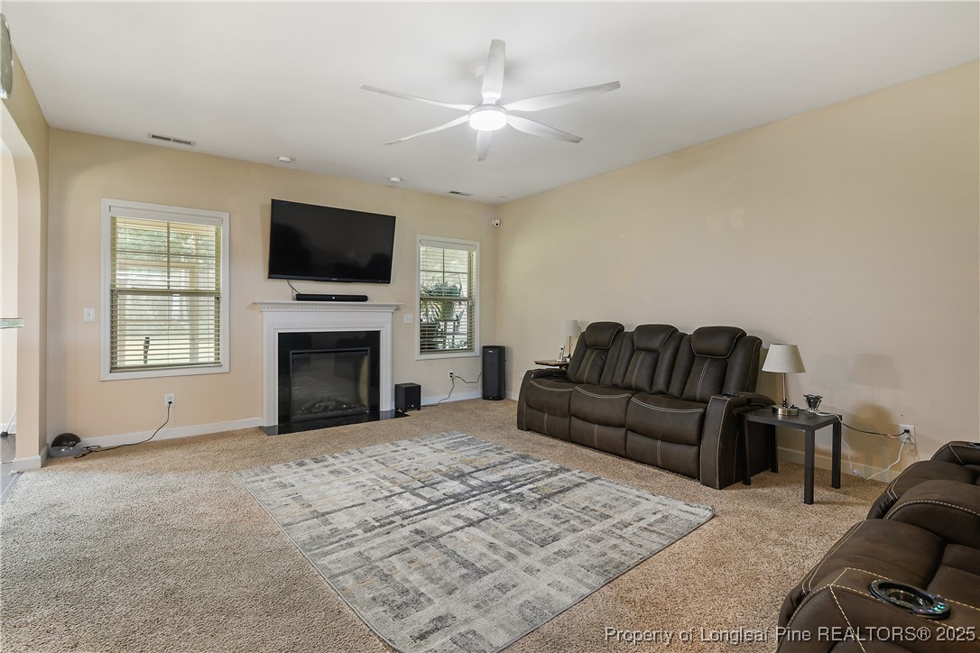945 Pecan Grove Loop Hope Mills, NC 28348 - Photo 7 of 42 a living room with furniture a flat screen tv and a fireplace
