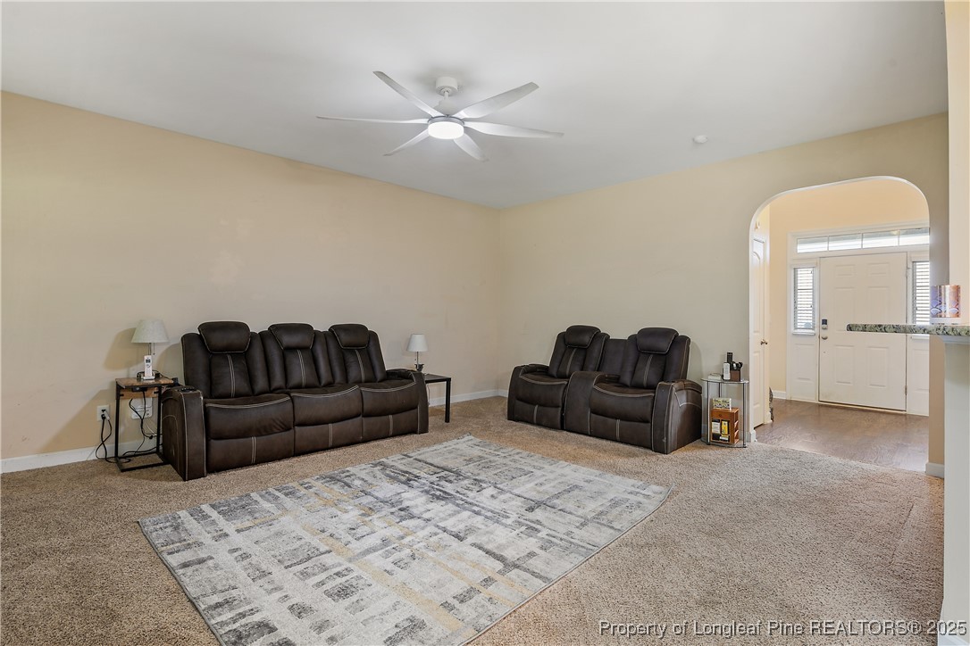 945 Pecan Grove Loop Hope Mills, NC 28348 - Photo 8 of 42 a living room with furniture a ceiling fan and a rug