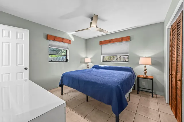 a bedroom with a large bed a chandelier and dresser