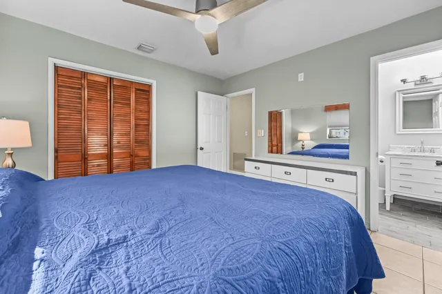 a bathroom with a granite countertop toilet sink vanity and mirror