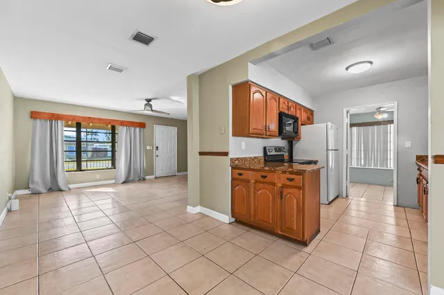 a large kitchen with stainless steel appliances granite countertop a refrigerator and a sink