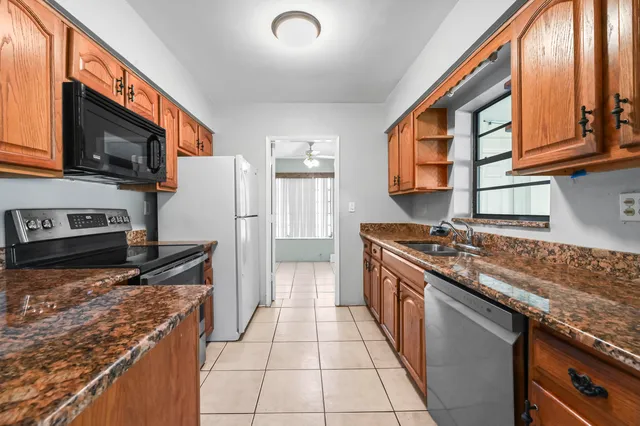 a kitchen with stainless steel appliances granite countertop a stove top oven a sink and dishwasher