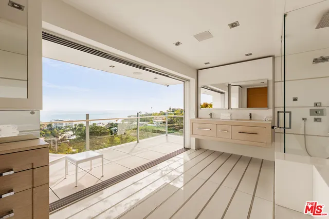 a view of a large white kitchen with granite countertop a large window and a sink