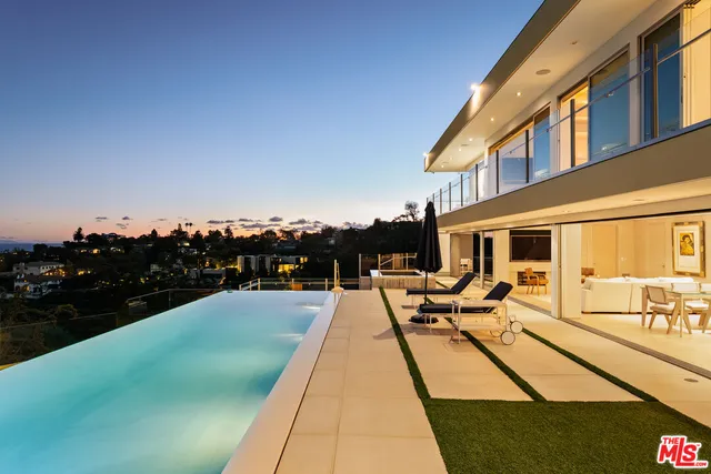 a view of swimming pool with outdoor seating and city view