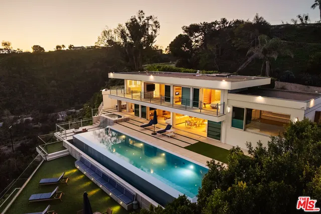 a view of a house with pool and chairs