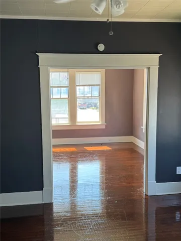 a view of empty room with window and wooden floor