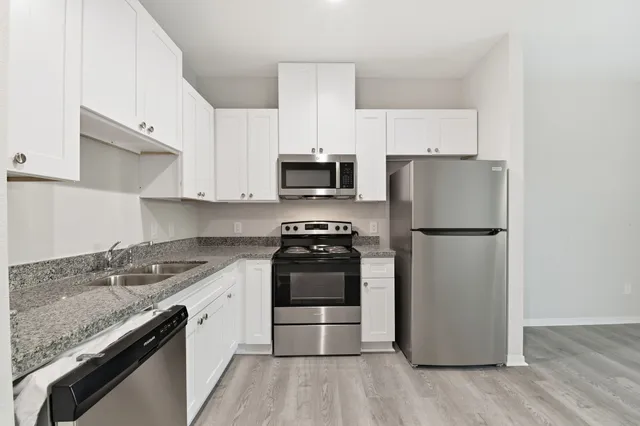 a kitchen with a stove a refrigerator and a sink