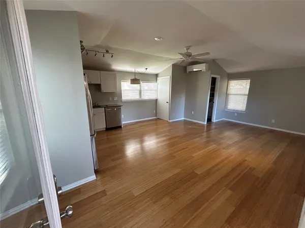 wooden floor in an empty room with a kitchen