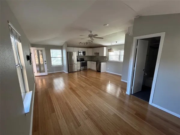 a view of a kitchen with a sink and wooden floor