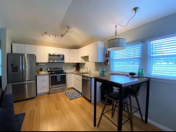 a kitchen with stainless steel appliances kitchen island a refrigerator and a stove