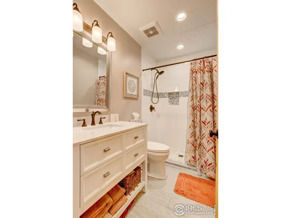 a bathroom with a sink a toilet a shower and a mirror