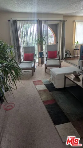 a living room with couches bookshelf and a large window