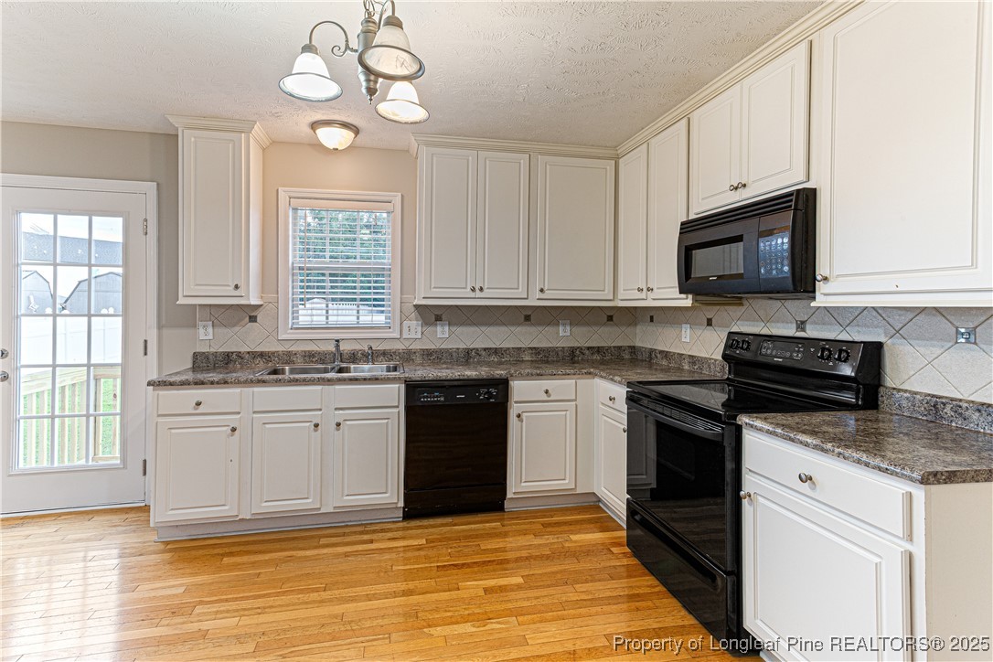 3831 Talus Road Fayetteville, NC 28306 - Photo 13 of 41 a kitchen with granite countertop stainless steel appliances a stove sink microwave and window