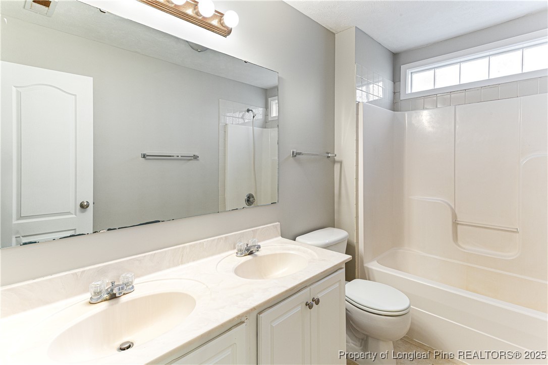3831 Talus Road Fayetteville, NC 28306 - Photo 32 of 41 a bathroom with a sink toilet a mirror and shower