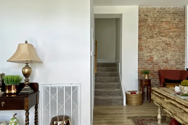 a living room with furniture and a air conditioner vent