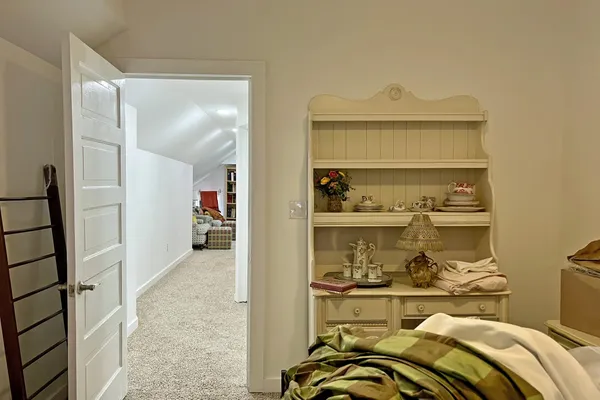 a bedroom with a couch and a book shelf