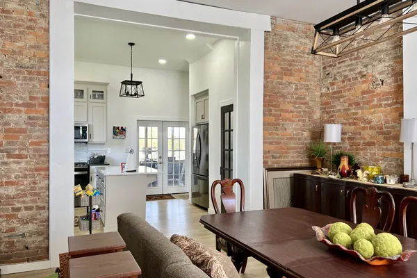 a kitchen with stainless steel appliances granite countertop a refrigerator a sink and white cabinets