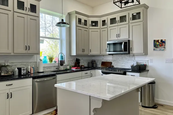 a kitchen with stainless steel appliances granite countertop a sink stove and cabinets