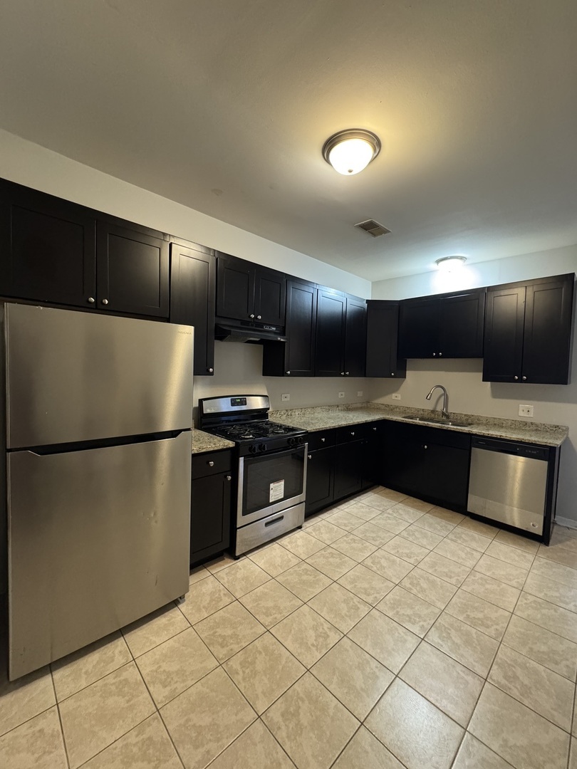 6130 South Rhodes Avenue, Unit 2 Chicago, IL 60637 - Photo 9 of 9 a kitchen with stainless steel appliances a refrigerator sink and microwave