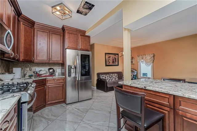 a kitchen with stainless steel appliances granite countertop a stove refrigerator sink and cabinets