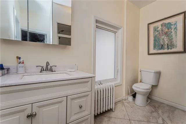 a bathroom with a toilet a sink and mirror