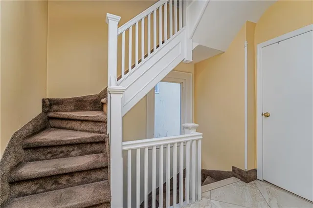 a view of staircase with lots of frames on wall and a window