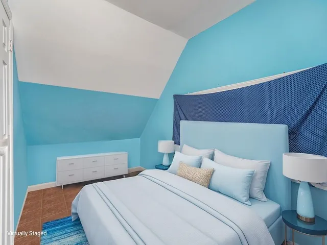 a bedroom with a bed and a painting on the wall