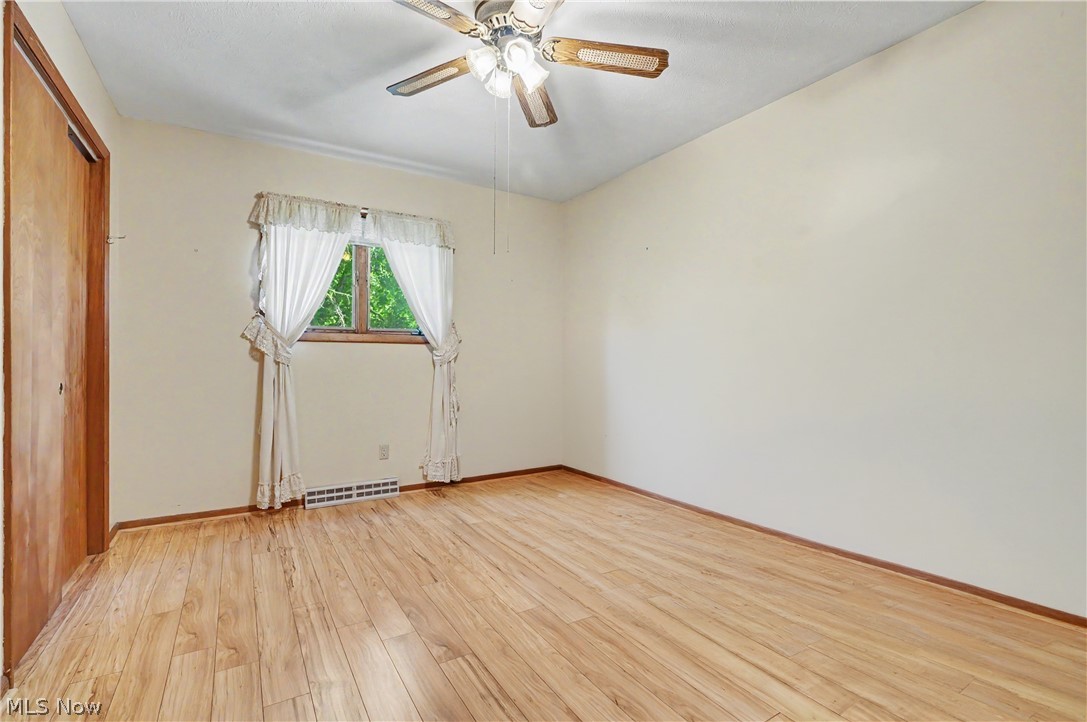 4250 Herr Fieldhouse Road Southington, OH 44470 - Photo 15 of 50 Room featuring wood-finish flooring, a ceiling fan with light fixture, and a window with wood trim