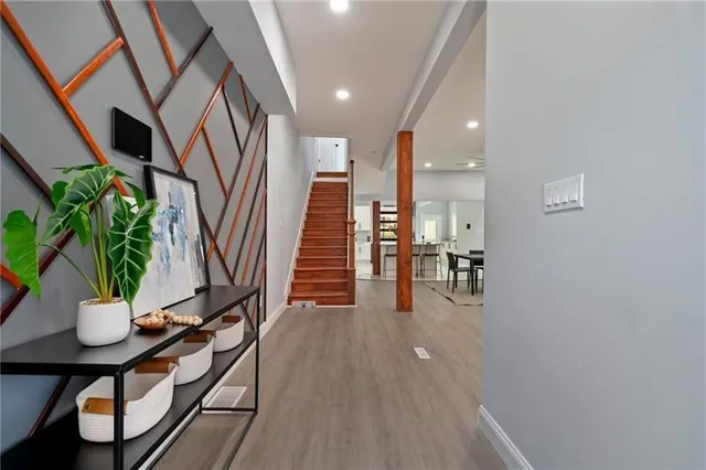 a hallway with wooden floor stairs and furniture