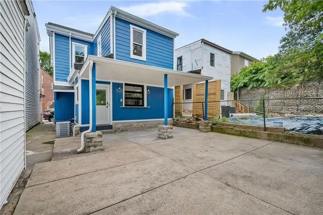 a view of a house with backyard and trees